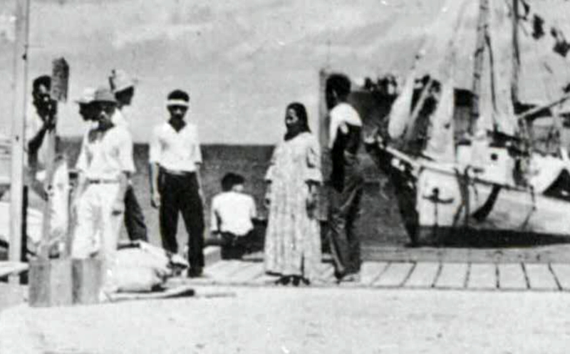 Cropped version of the photo purporting to show Amelia Earhart alive and sitting on a dock in 1937, despite the fact that the US National Archives does not have a date for the image (U.S. National Archives, Records of the Office of Naval Intelligence, Record Group 38, Monograph Files Relating to the Pacific Ocean Area, NAID 68141661)
